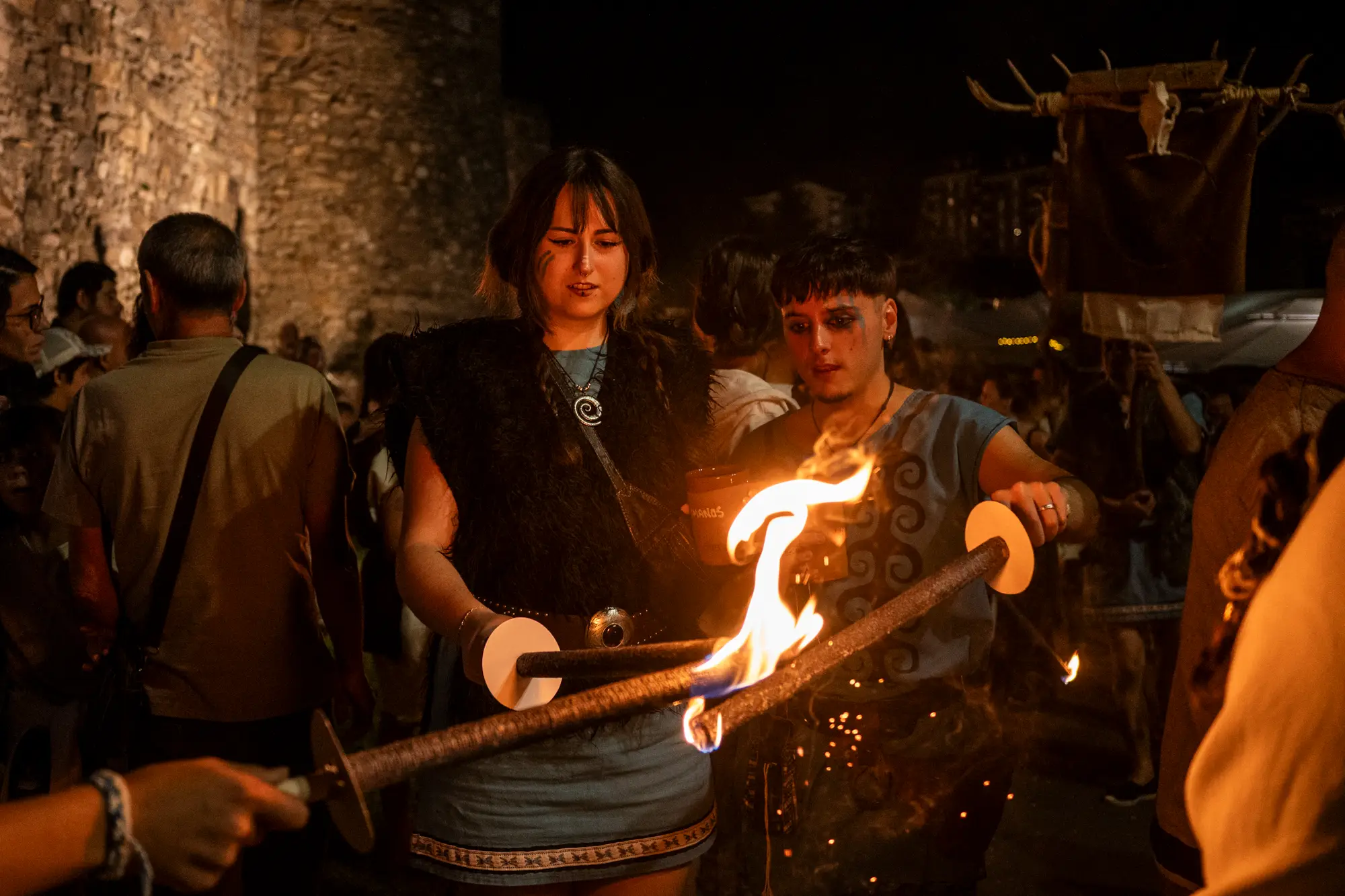 Participantes encendiendo antorchas para la Marcha de Fuego
