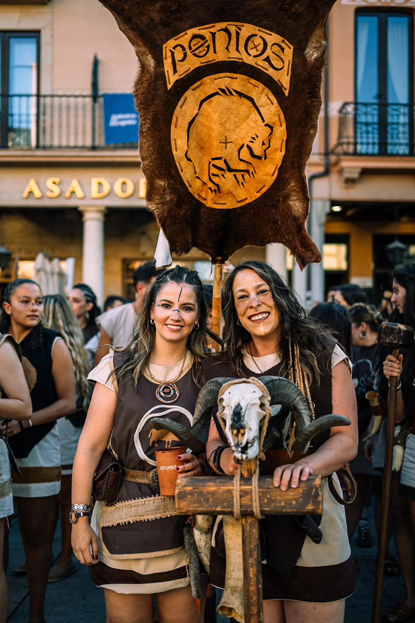 Dos mujeres de una tribu astur posando con su estandarte