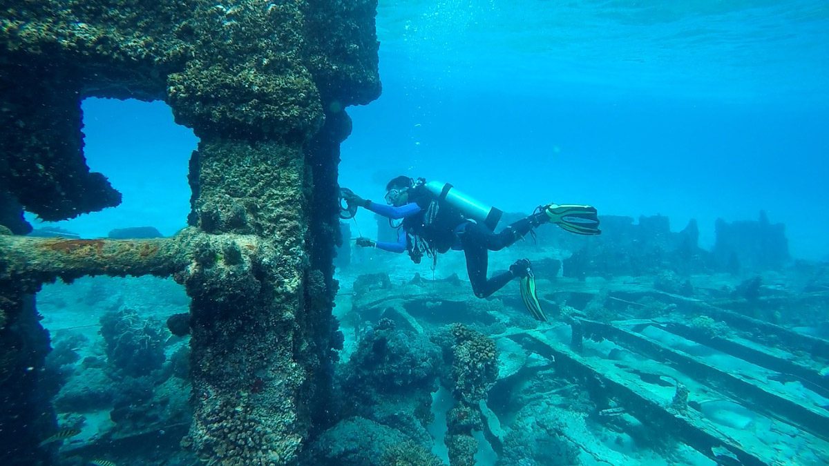 Submarinista inspeccionando un barco hundido