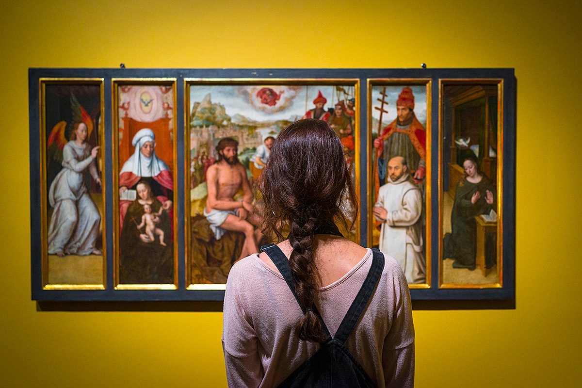 Una joven observa un cuadro en el Groeninge Museum de Brujas