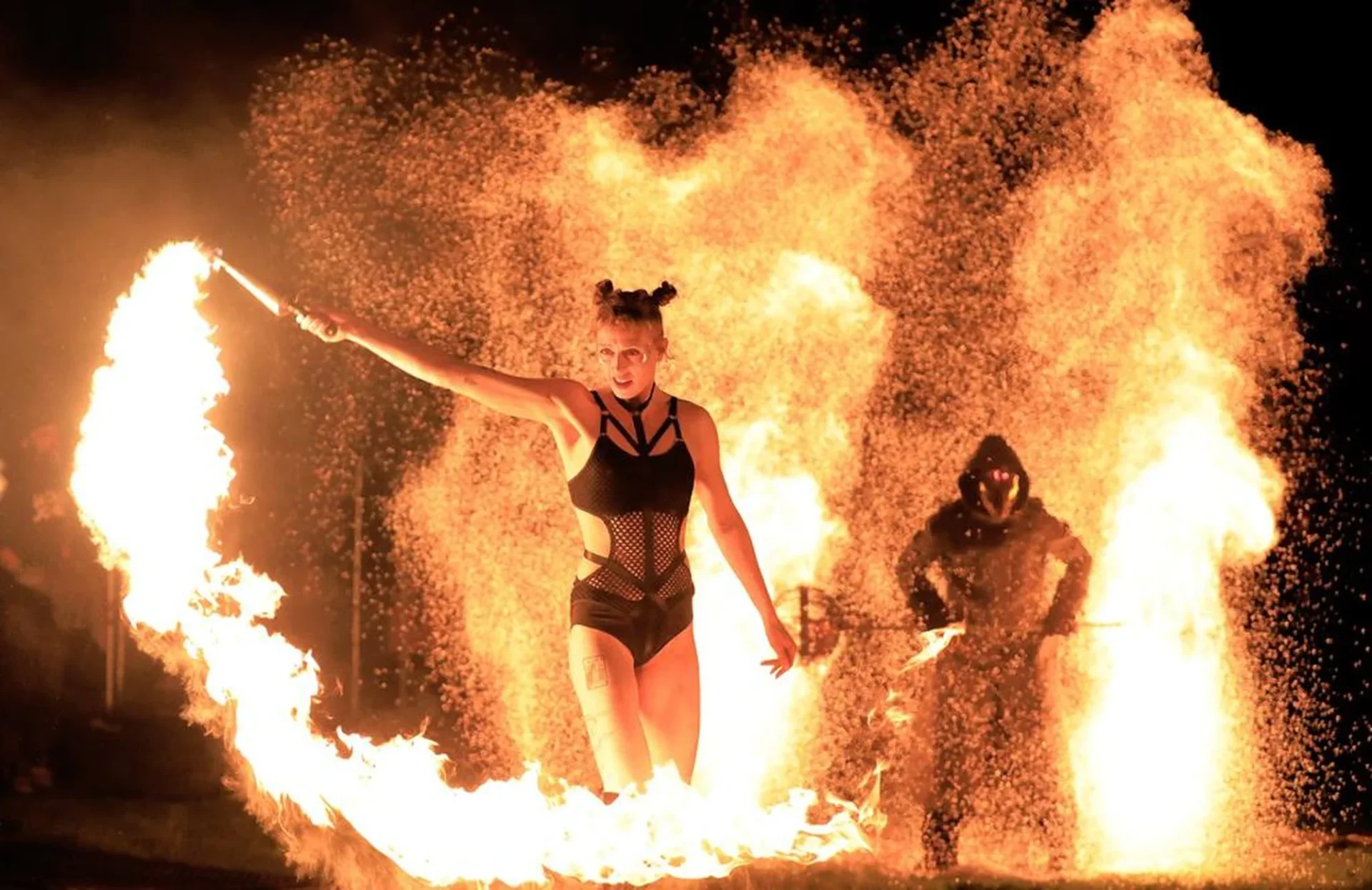 Artista de Pyro Collective con una antorcha, rodeada de llamas durante el Púca Festival de 2022 en Trim, Irlanda. © Harris PR