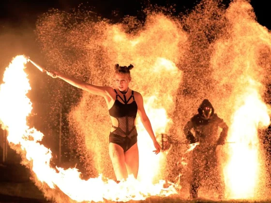 Artista de Pyro Collective con una antorcha, rodeada de llamas durante el Púca Festival de 2022 en Trim, Irlanda. © Harris PR