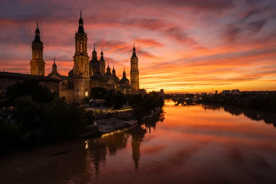 Basílica del Pilar junto al Ebro, con el cielo anaranjado del atardecer. © Javier García Blanco