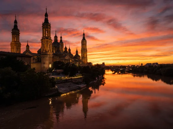 Basílica del Pilar junto al Ebro, con el cielo anaranjado del atardecer. © Javier García Blanco