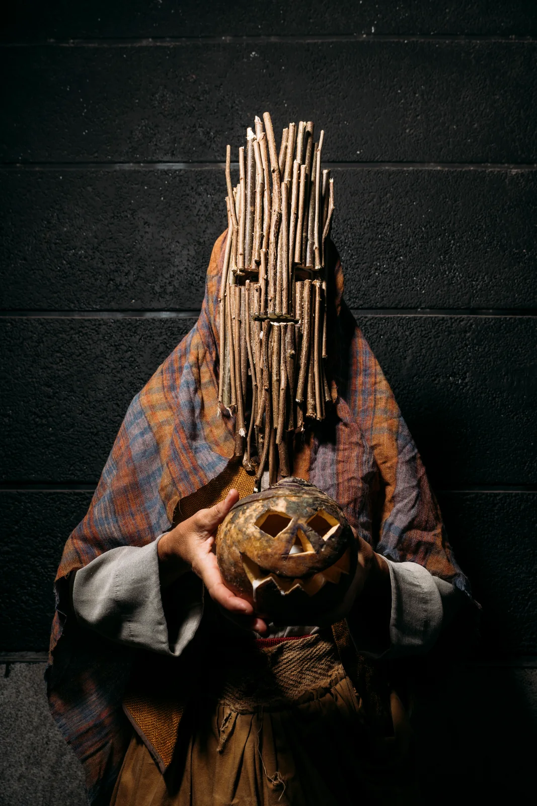 Personaje con máscara de varas y una calabaza tallada en las manos en una imagen promocional de Samhain de 2025. © Sergio Albert Avilés