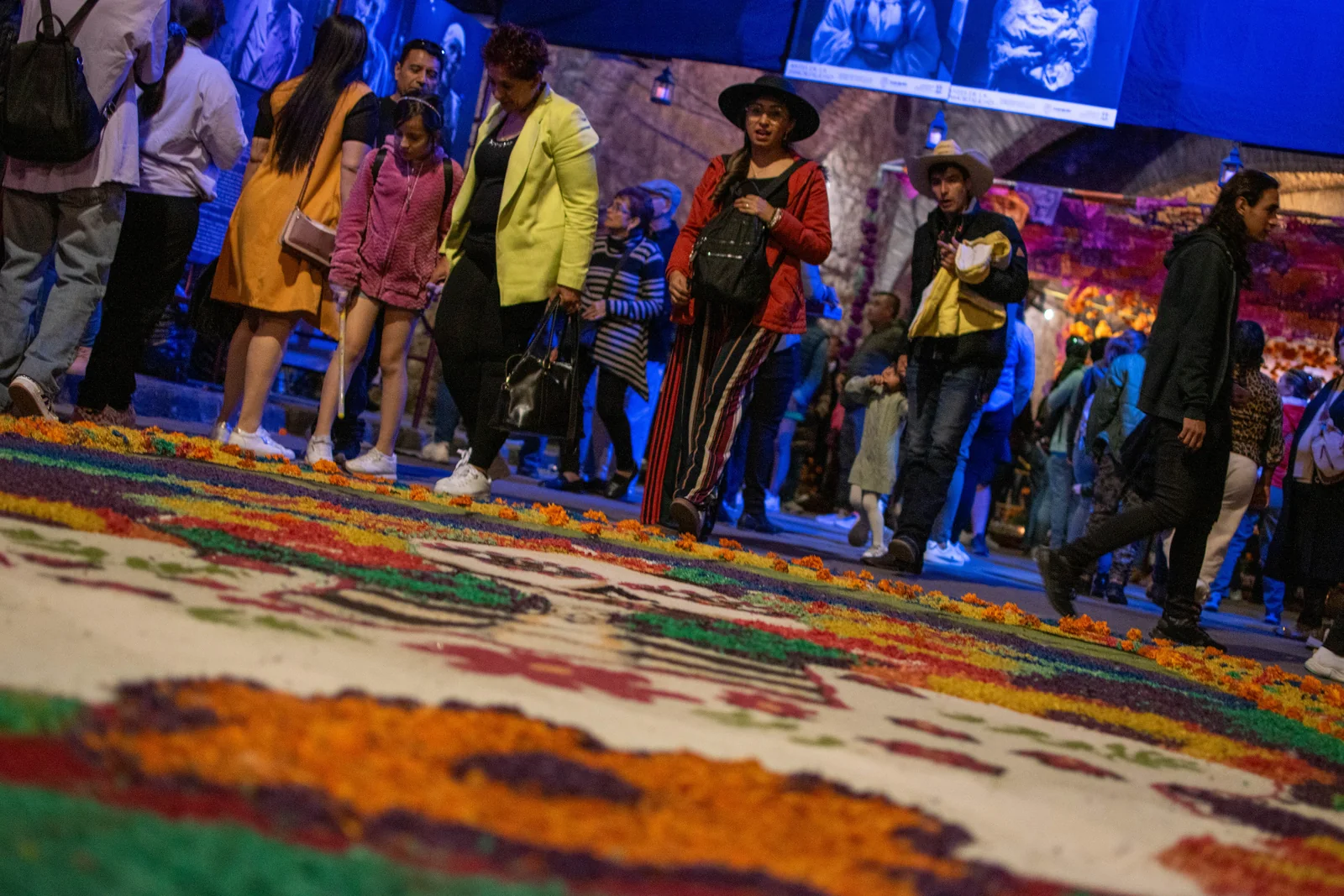 Visitantes contemplan un tapete de colores del Día de Muertos en el Túnel de Tradición de Guanajuato.