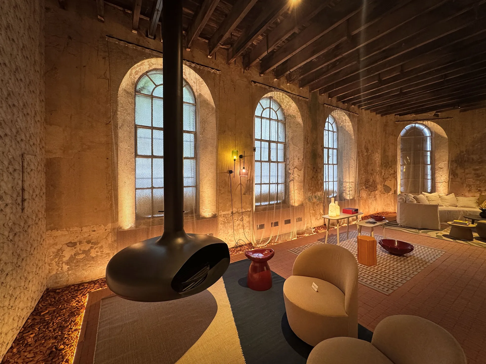 Sala con sillones, ventanas de arco y paredes de ladrillo en Palacio Molina, Buenos Aires