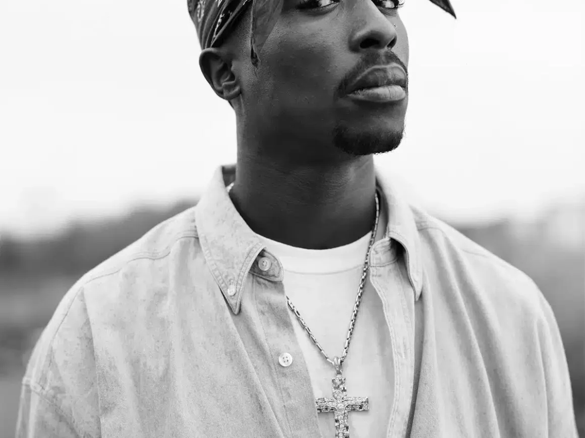 Retrato en blanco y negro de Tupac Shakur con pañuelo anudado y camisa abierta, realizado en 1993. © Dana Lixenberg